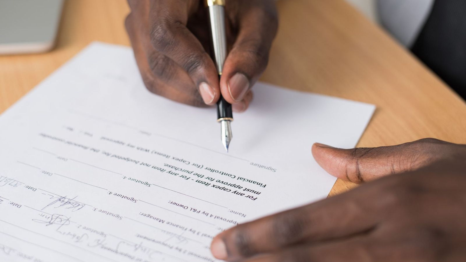 Une main qui signe un contrat au stylo plume